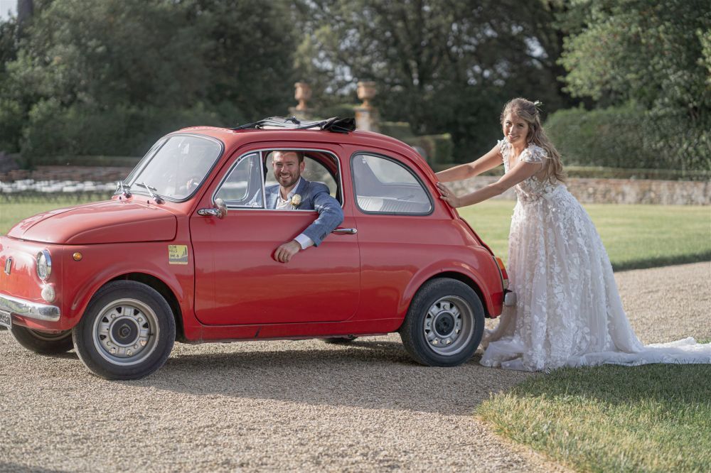 Bride and groom with vintage car at the panoramic villa in the Tuscan countryside