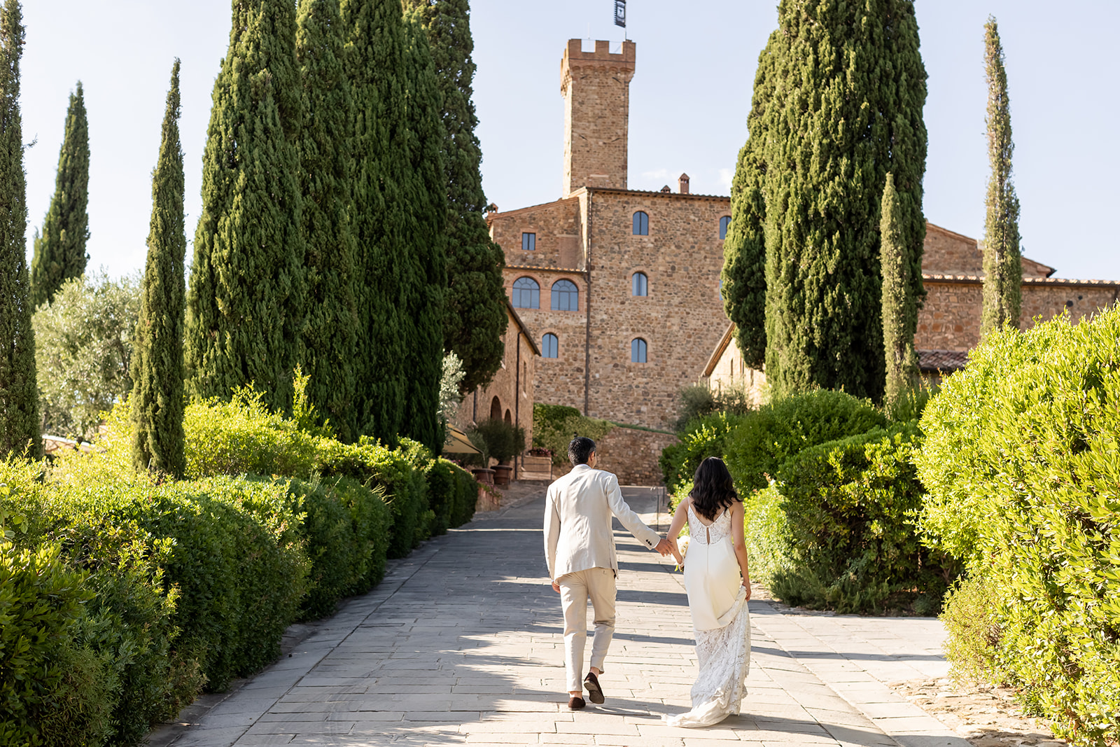 Bride and groom with the view of the wedding venue in Tuscany