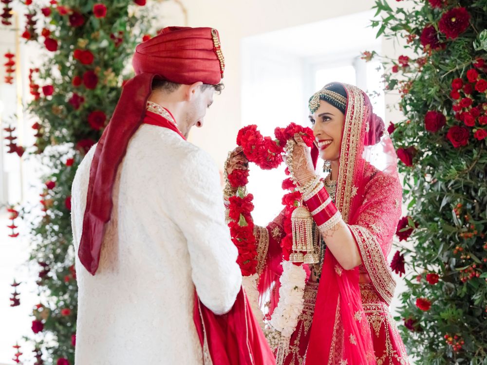 Bride and groom with red flowers at the Indian wedding