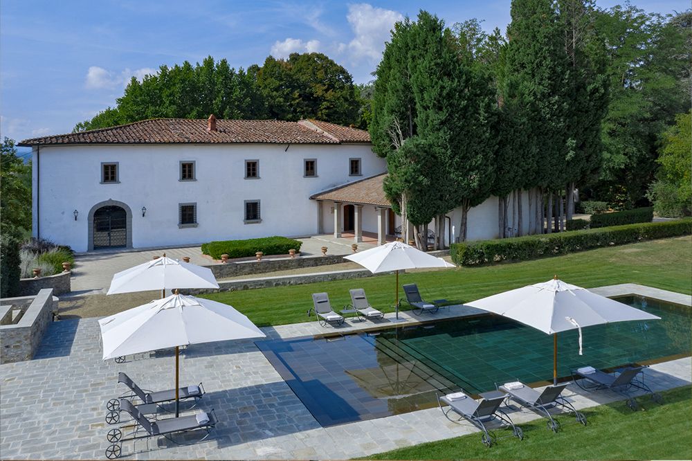 Pool and villa with sun umbrellas at the luxury wedding resort in the Tuscan countryside