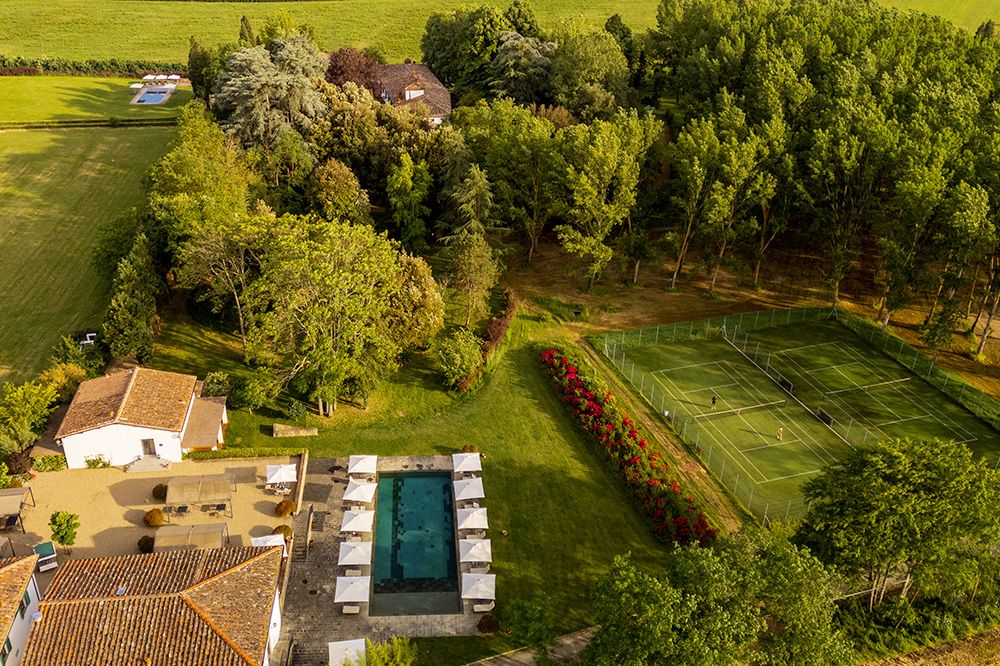 View of the tennis court and pool at the luxury wedding resort in the Tuscan countryside