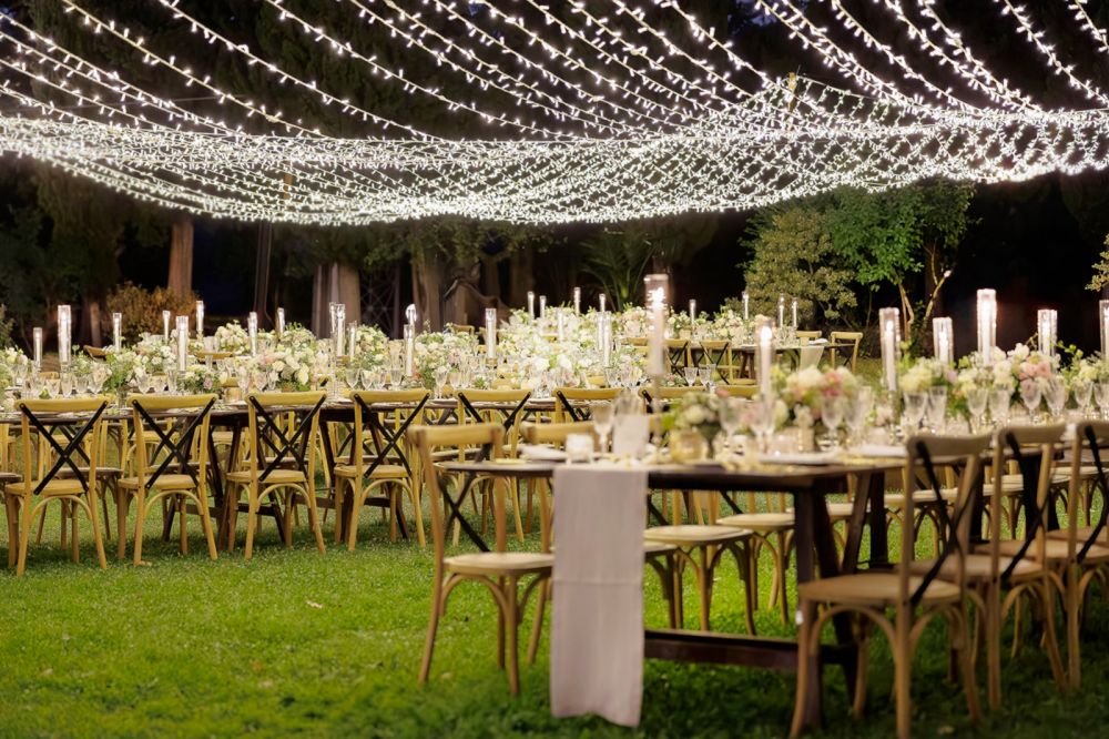 Wooden tables with fairy lights at the wedding villa in Florence