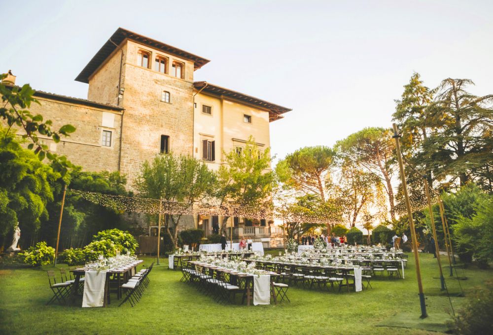 Wooden tables with fairy lights at the wedding villa in Florence